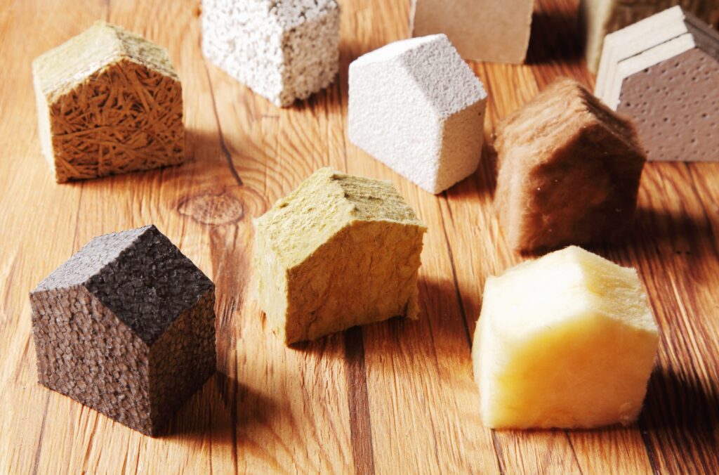 Close up Various Scattered Blocks of insulation Model Hous in Different Standing on Top of the Wooden Table