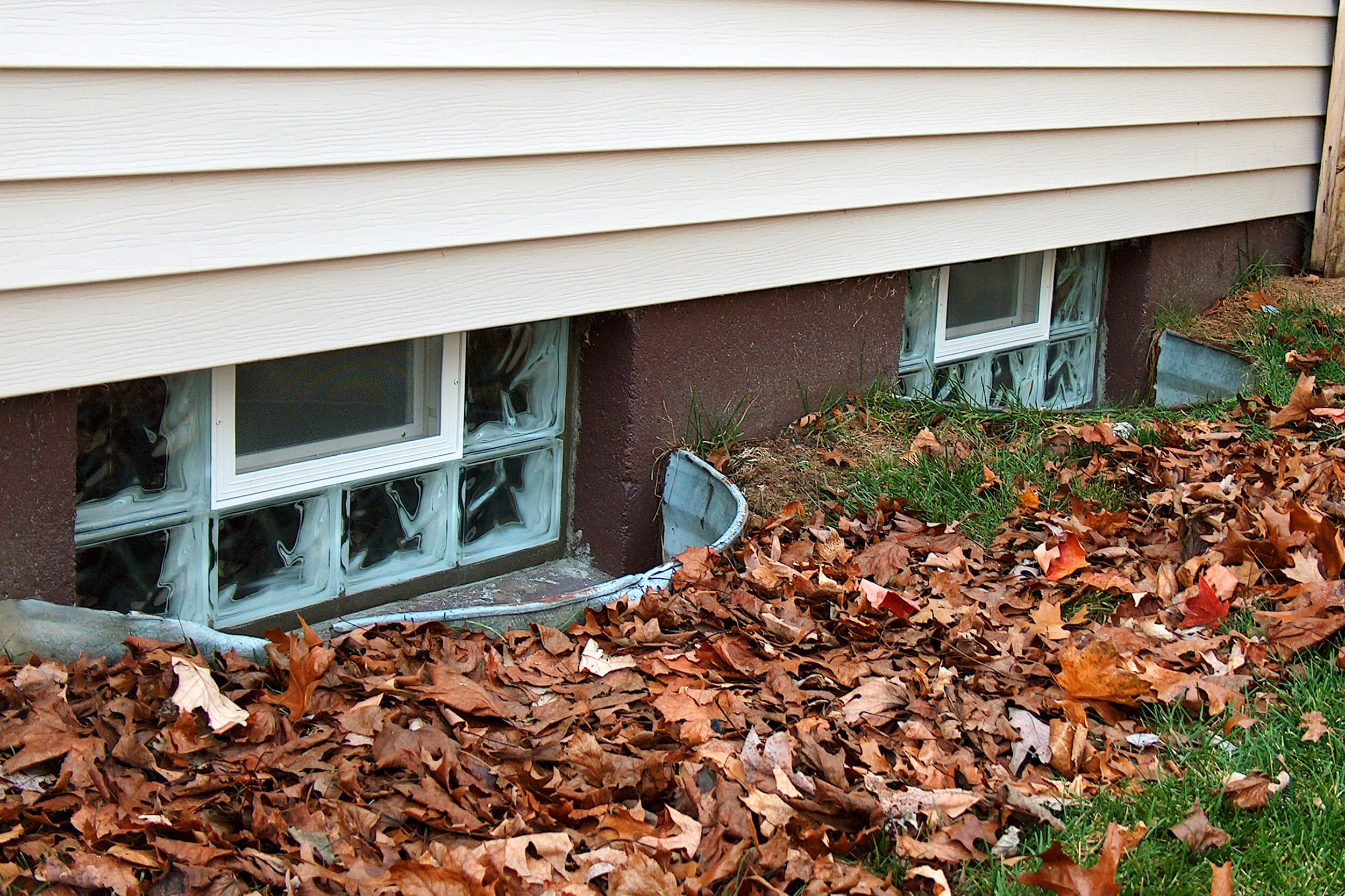 Glass block basement window in the fall (with leaves)