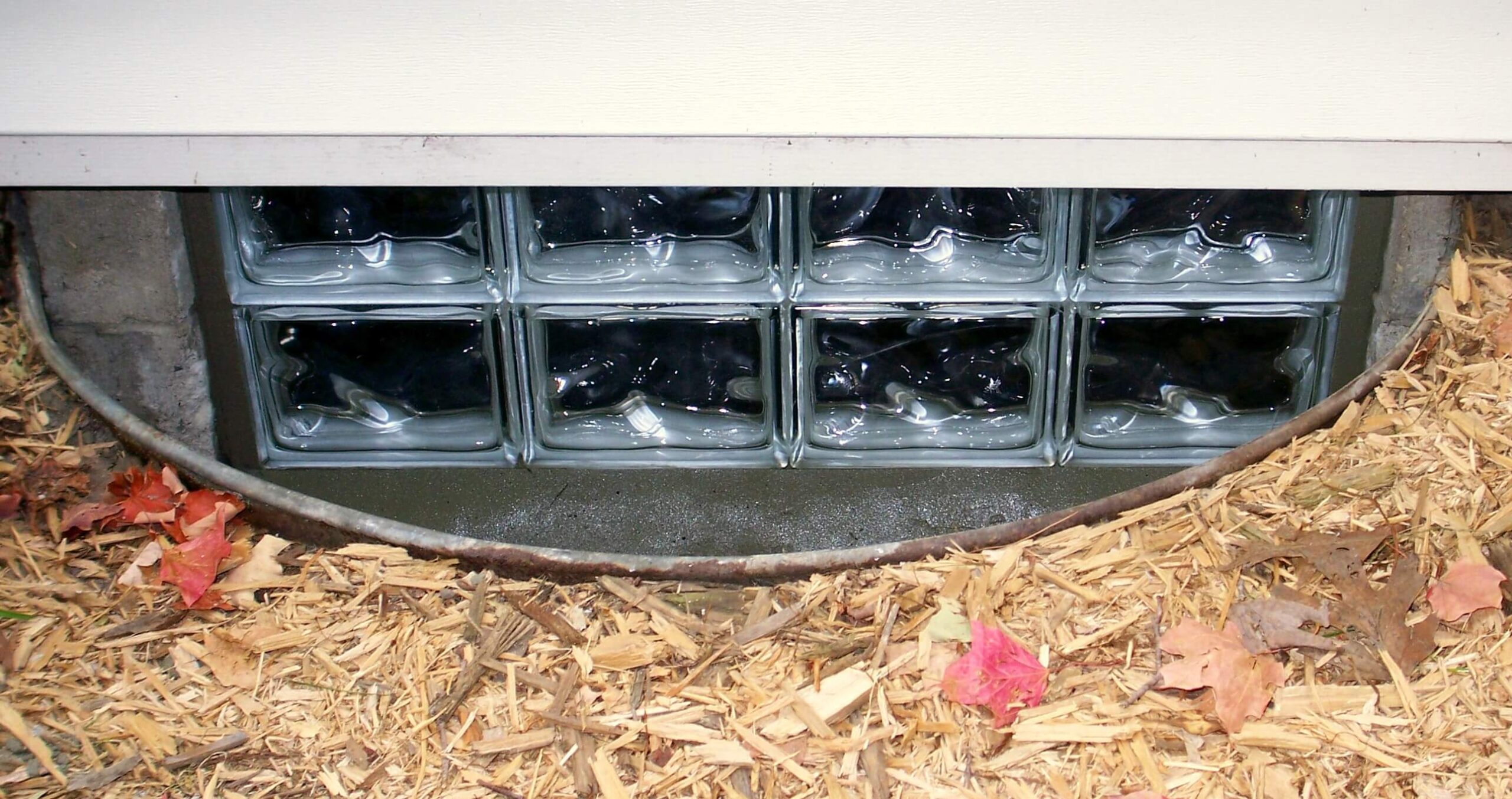 Glass block installation on window well of a house