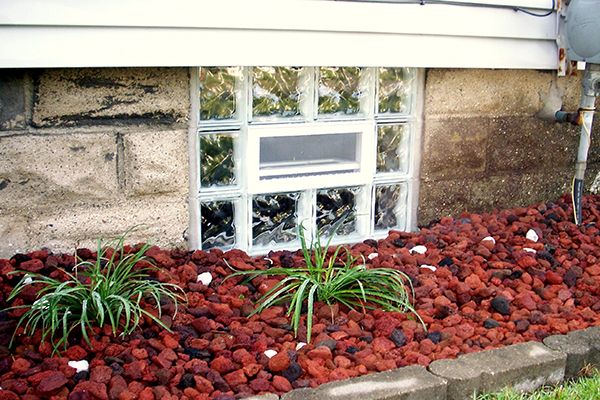 glass block basement window next to garden